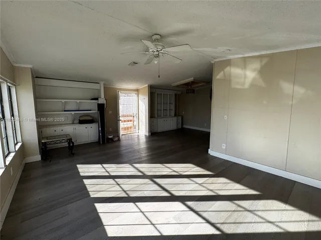 a view of a hallway view with wooden floor and cabinets