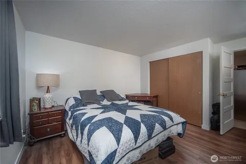 a bedroom with a bed and wooden floor