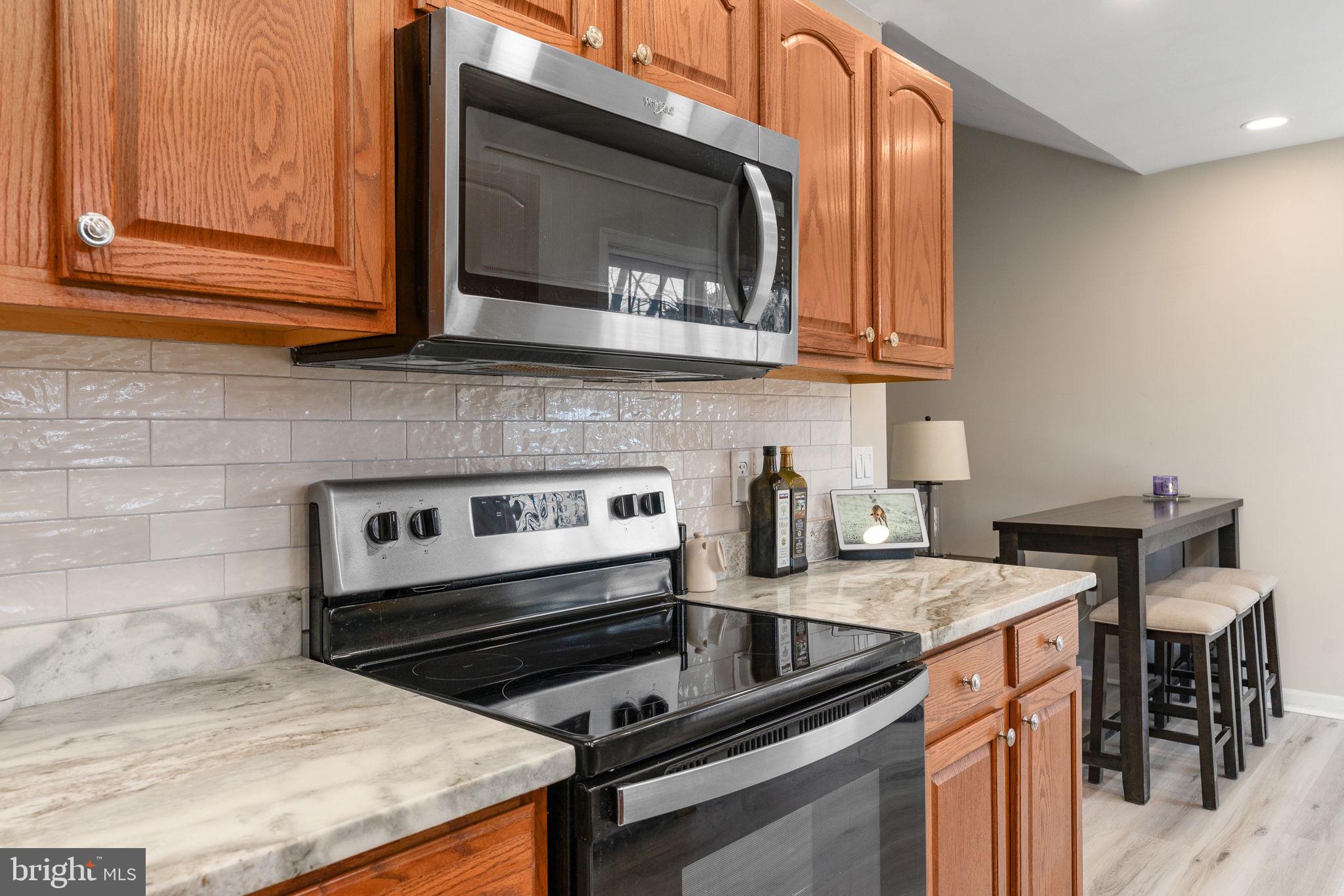 219 Santa Maria Avenue Colonial Beach, VA 22443 - Photo 15 of 52 a kitchen with stainless steel appliances granite countertop a stove a sink and a microwave
