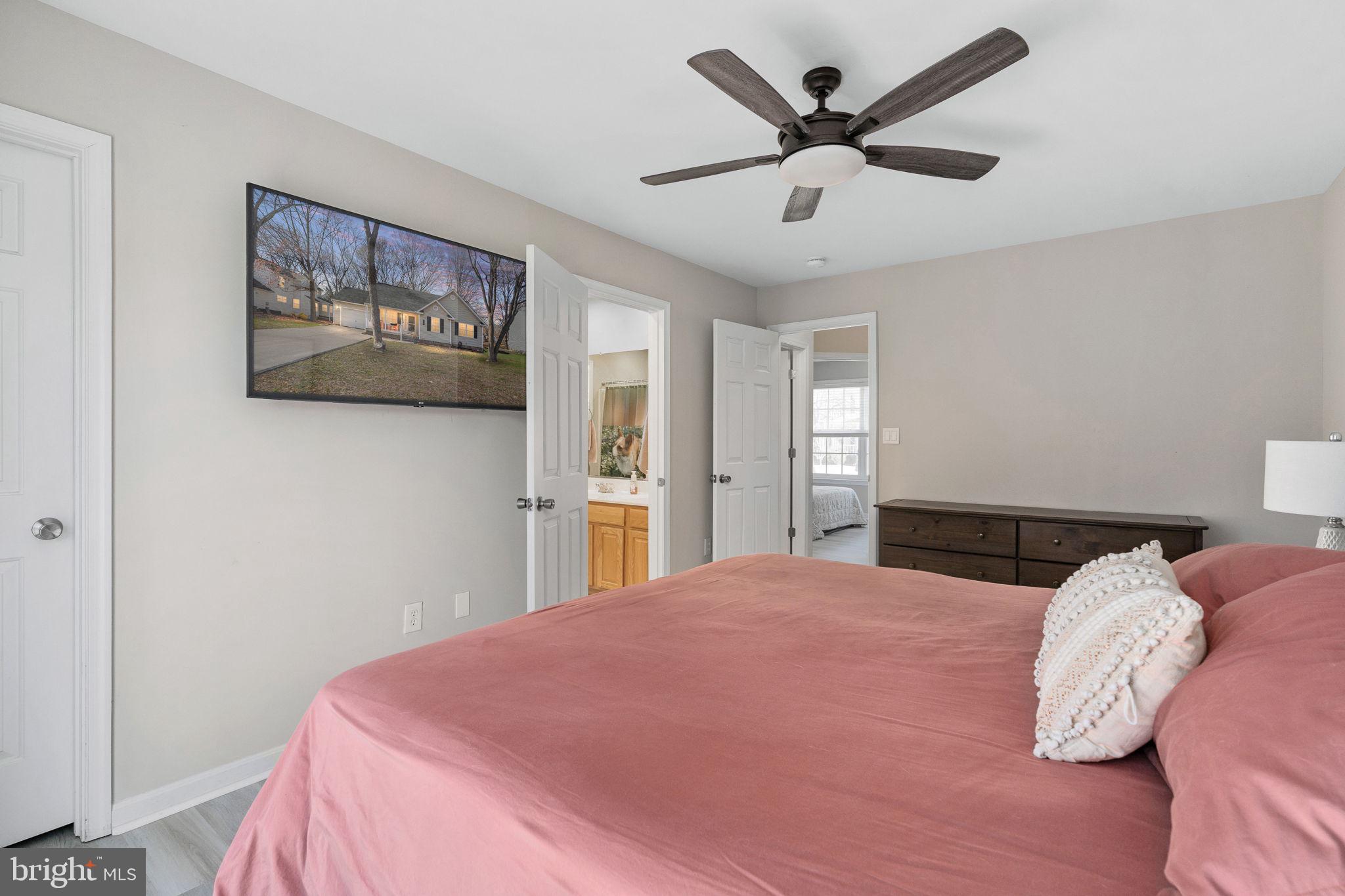 219 Santa Maria Avenue Colonial Beach, VA 22443 - Photo 23 of 52 a bedroom with a large bed and a chandelier