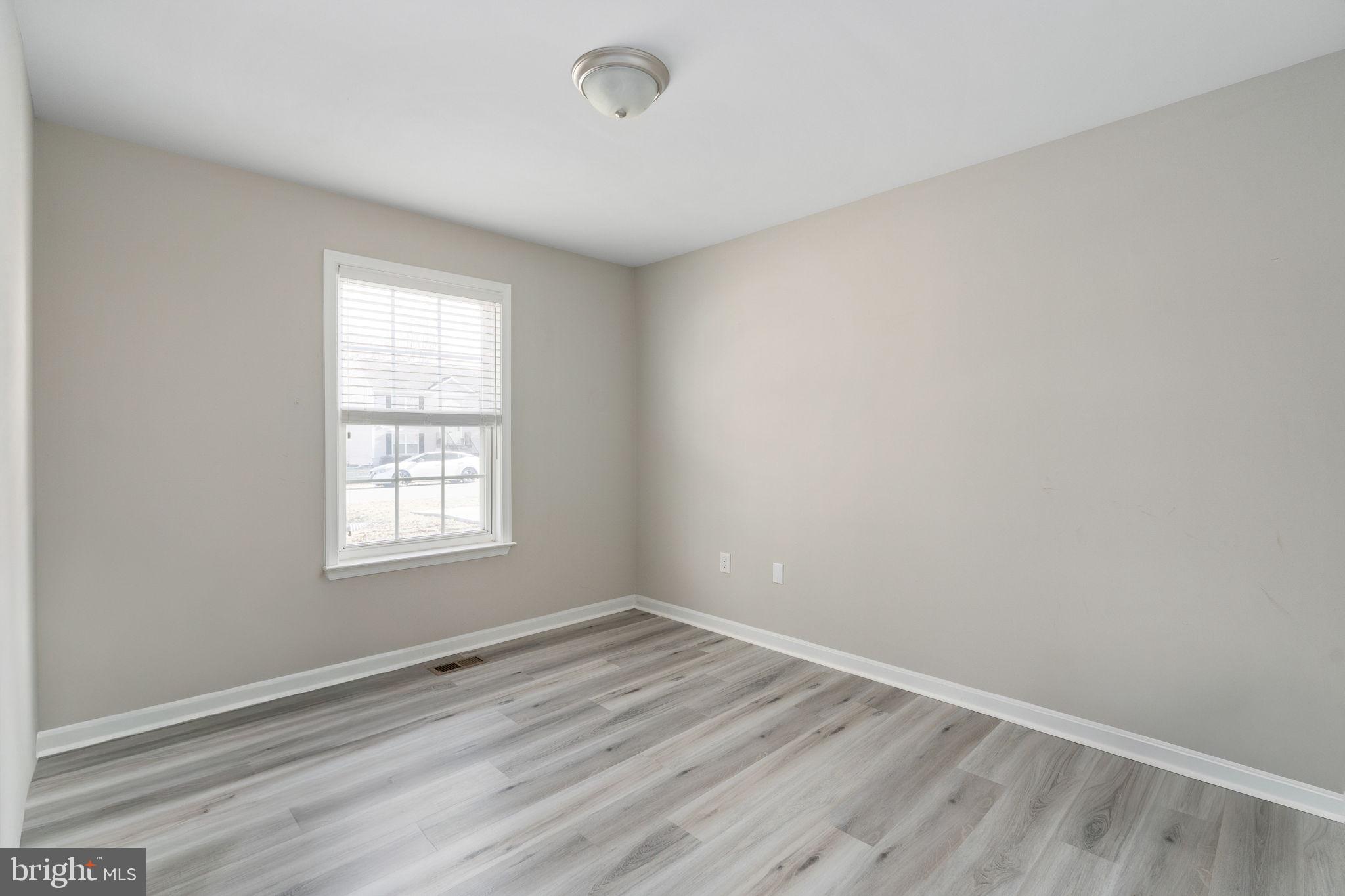 219 Santa Maria Avenue Colonial Beach, VA 22443 - Photo 26 of 52 an empty room with wooden floor and windows