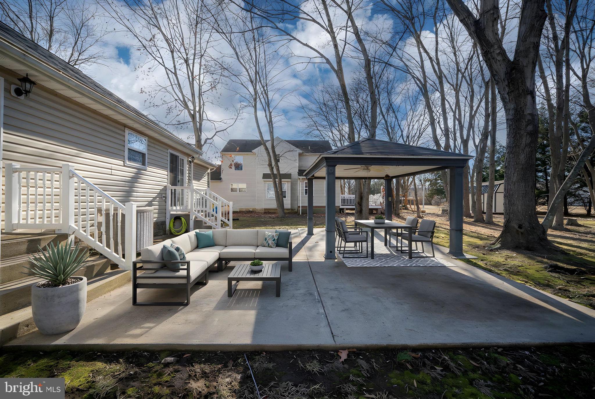 219 Santa Maria Avenue Colonial Beach, VA 22443 - Photo 40 of 52 a view of a patio with table and chairs potted plants and large tree