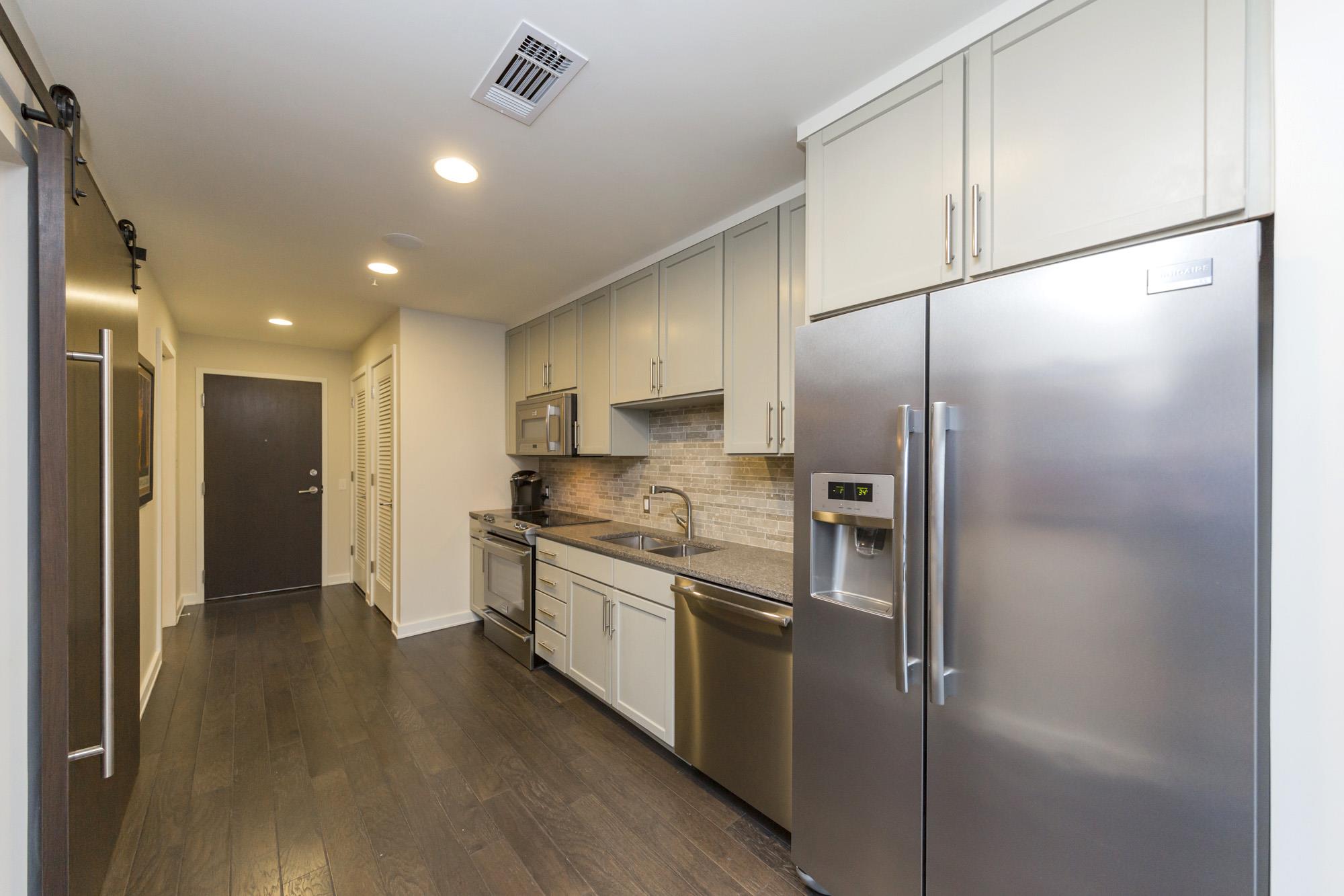 1212 Laurel Street, Unit 1312 Nashville, TN 37203 - Photo 12 of 22 a kitchen with stainless steel appliances granite countertop a refrigerator and a stove top oven