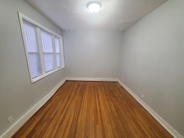 a view of a room with wooden floor and window