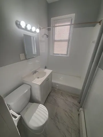 a bathroom with a toilet sink and mirror