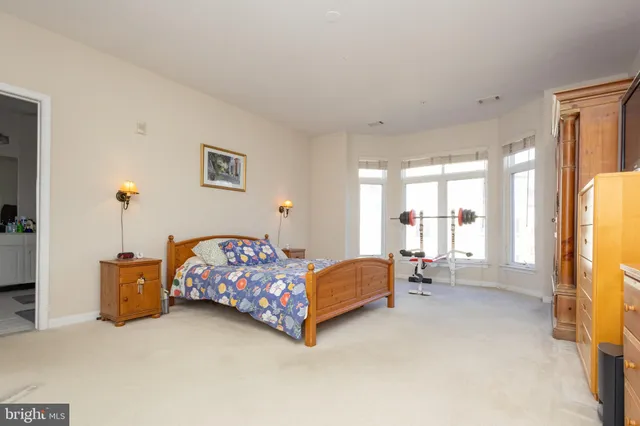 a bedroom with a bed and large windows