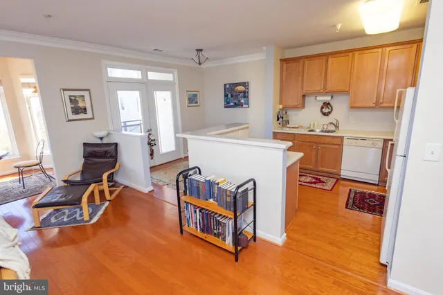 a living room with furniture a flat screen tv and a refrigerator