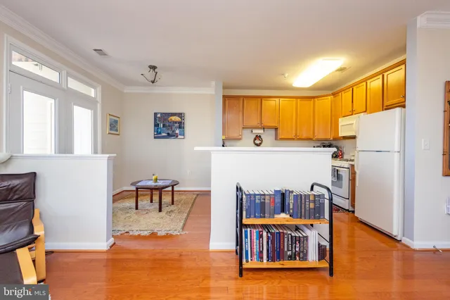 a kitchen with stainless steel appliances a refrigerator a stove a dining table and chairs