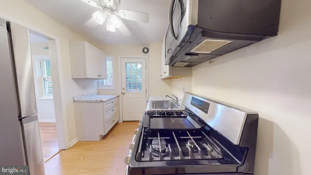 a kitchen with sink stove and refrigerator
