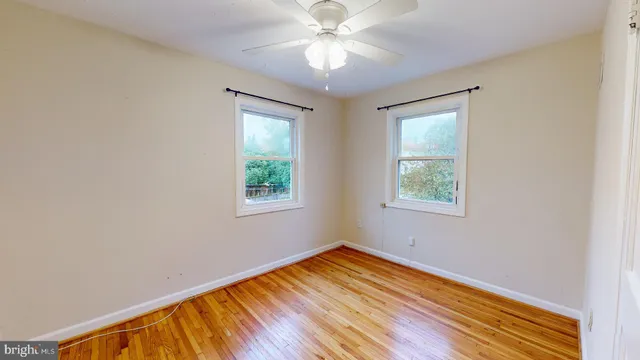 an empty room with a window and a ceiling fan