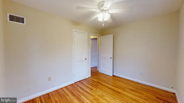a view of empty room with wooden floor