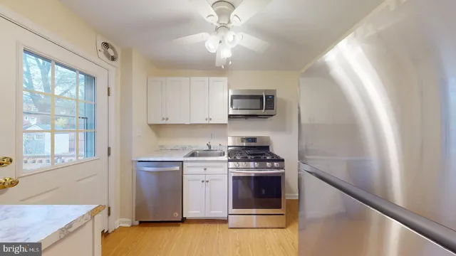 a kitchen with stainless steel appliances a stove a sink and a microwave