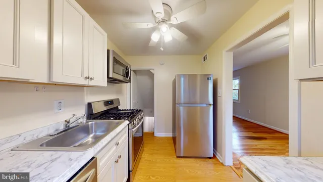 a kitchen with a sink a refrigerator and cabinets