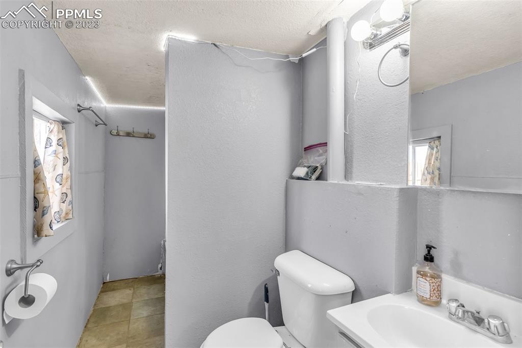 1417 2nd Road Pueblo, CO 81007 - Photo 15 of 32 a bathroom with a granite countertop sink mirror vanity and toilet