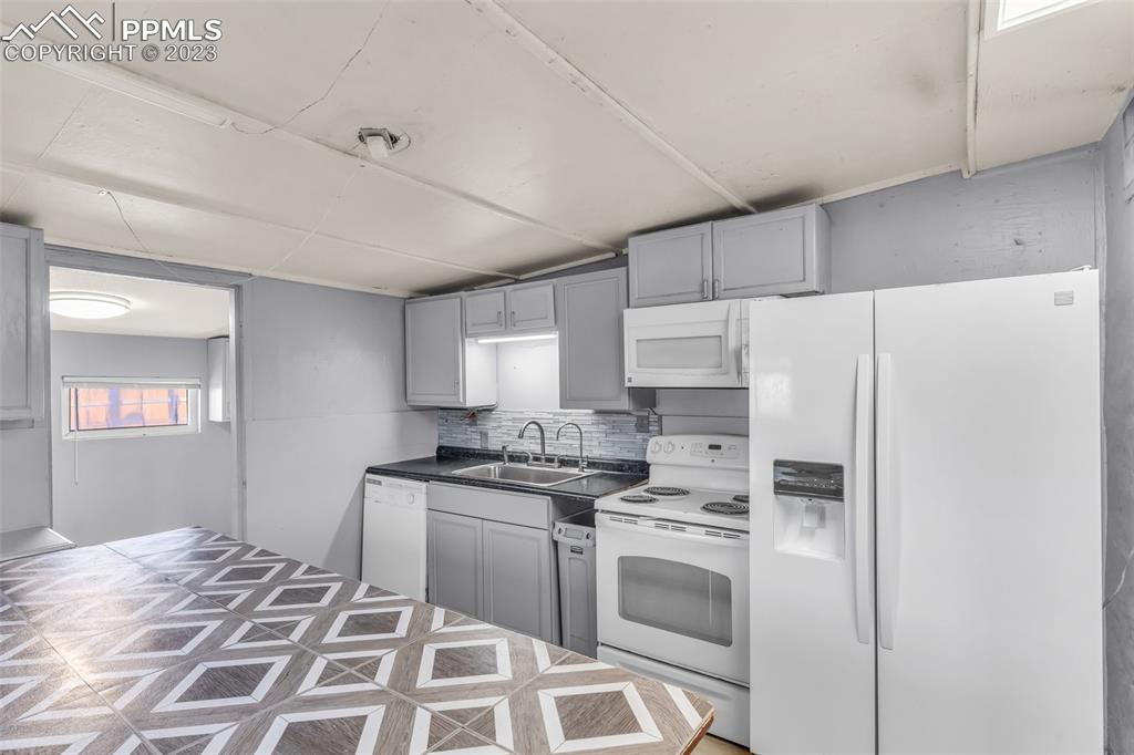 1417 2nd Road Pueblo, CO 81007 - Photo 9 of 32 a kitchen with a stove a sink and a refrigerator