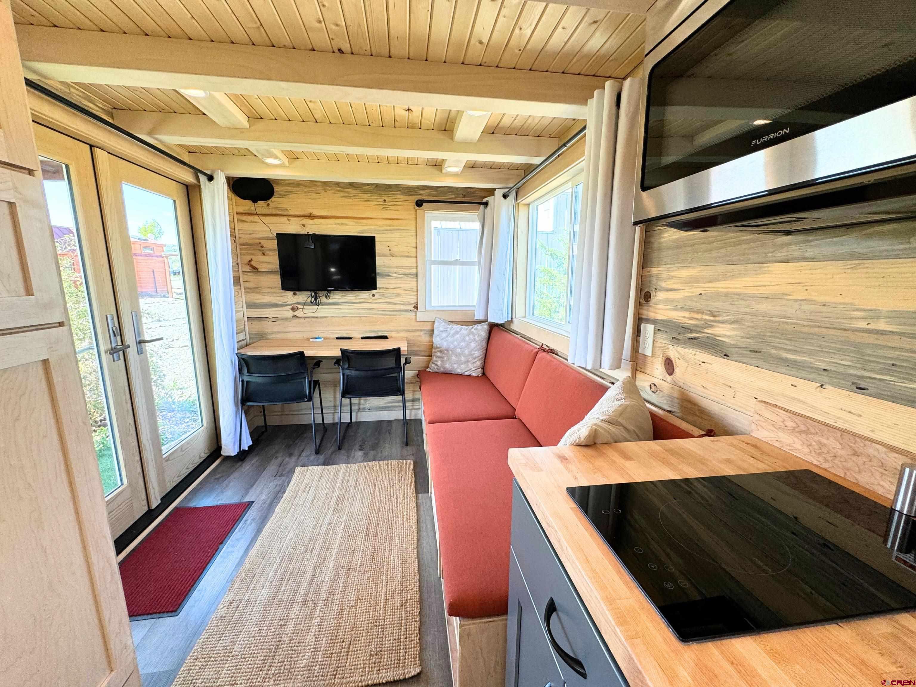 22130 6850 Road, Unit 212 Montrose, CO 81403 - Photo 5 of 29 a living room with furniture and a flat screen tv