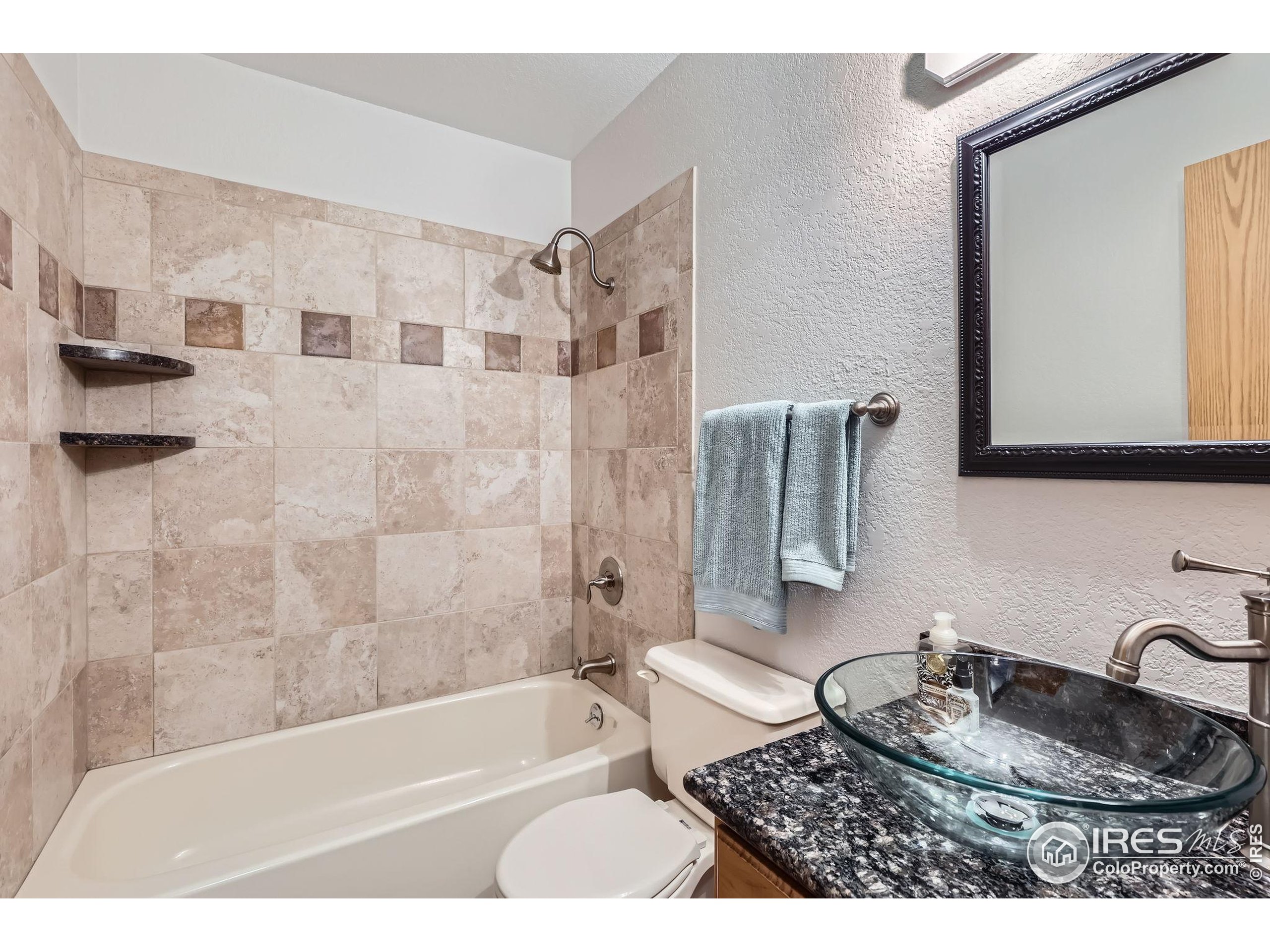 3515 28th Street, Unit 108 Boulder, CO 80301 - Photo 19 of 29 a bathroom with a granite countertop sink a toilet a mirror and bathtub