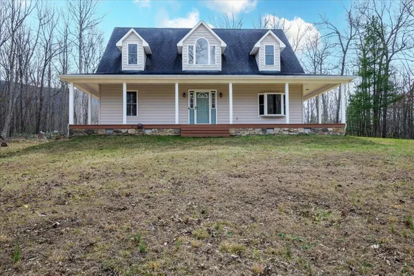 a view of a livingroom with wooden floor a fireplace and windows