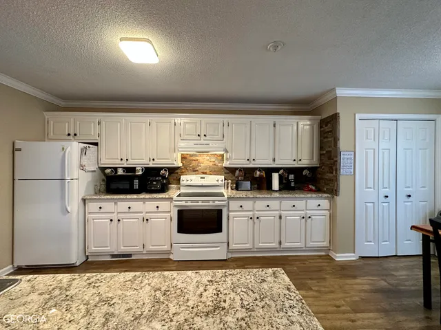 a kitchen with stainless steel appliances granite countertop a refrigerator sink and cabinets