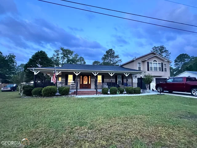 a view of a big house with a big yard and large trees