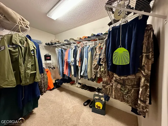 a view of walk in closet with clothes
