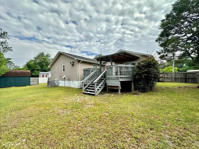 a view of a house with a yard and sitting area