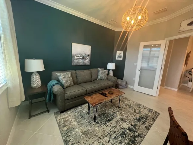 a living room with furniture and a chandelier