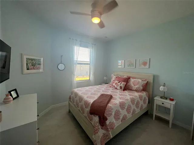 a bedroom with a bed and painting on the wall