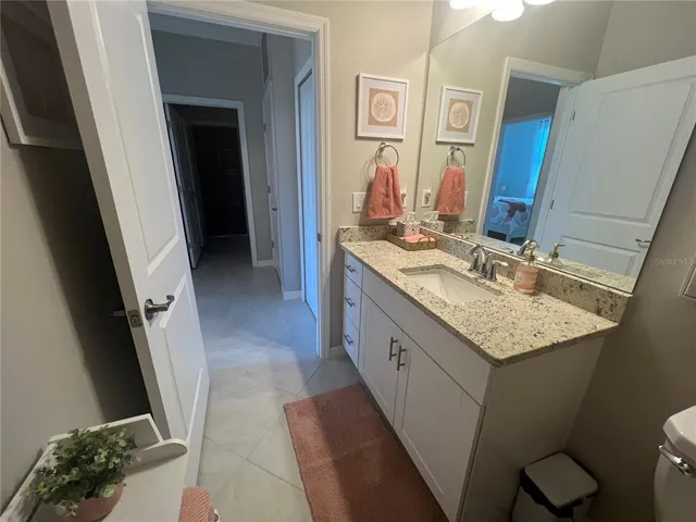a bathroom with a granite countertop sink and a mirror