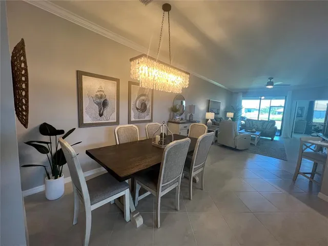 a view of a dining room with furniture and a chandelier