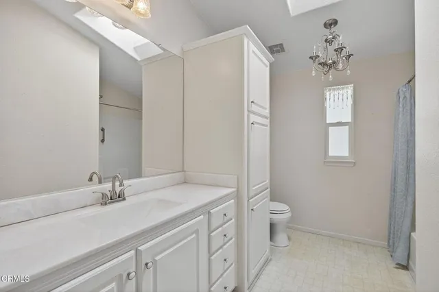 a bathroom with a granite countertop sink a toilet and a mirror