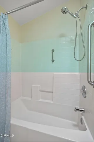 a bathroom with a bath tub with a shower