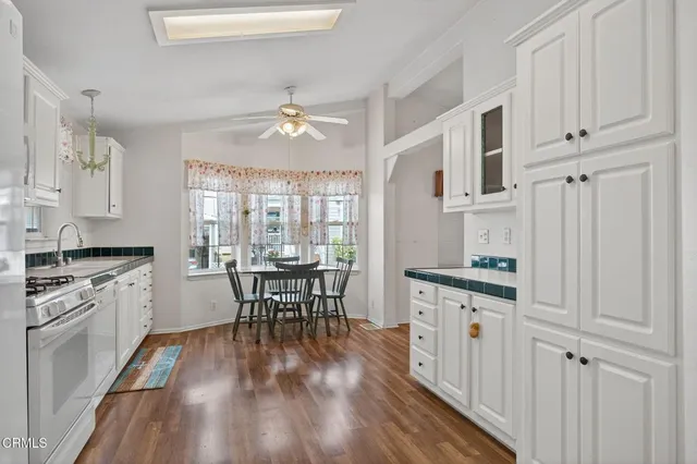 a kitchen with granite countertop a dining table chairs stainless steel appliances and cabinets