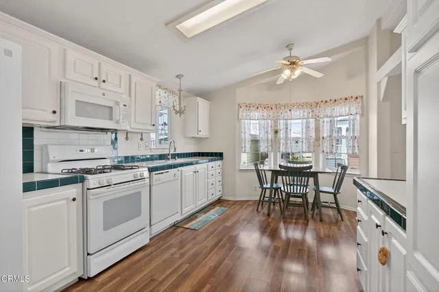 a kitchen with white cabinets and appliances