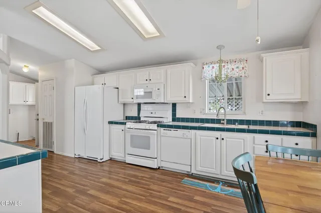 a kitchen with stainless steel appliances granite countertop a white cabinets and a refrigerator