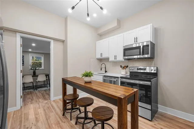 a kitchen with a stove cabinets and wooden floor