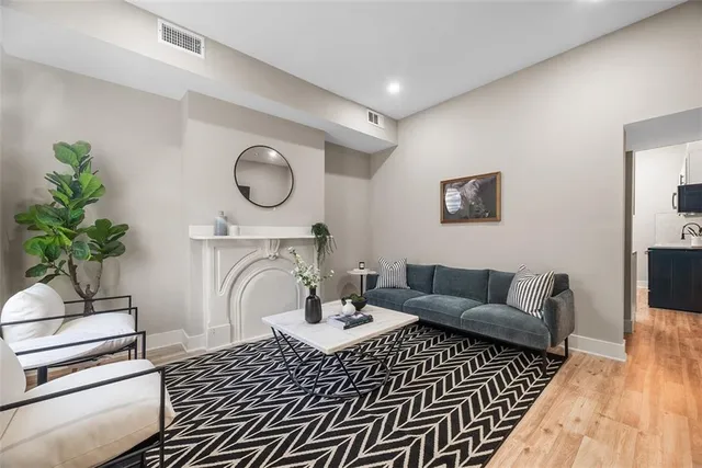 a living room with furniture a fireplace and a potted plant
