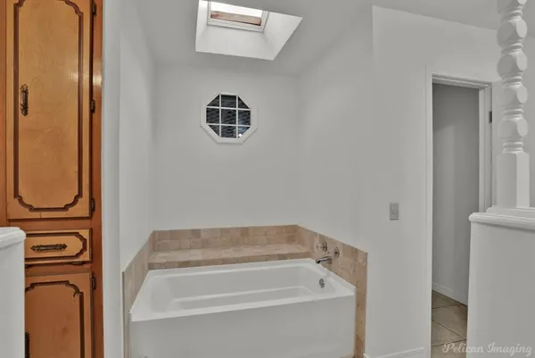 a bathroom with a bathtub and a window