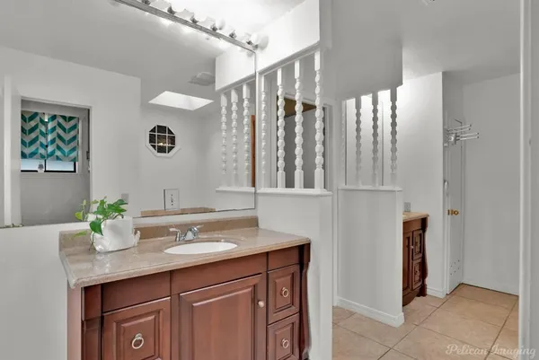 a bathroom with a granite countertop sink and a mirror