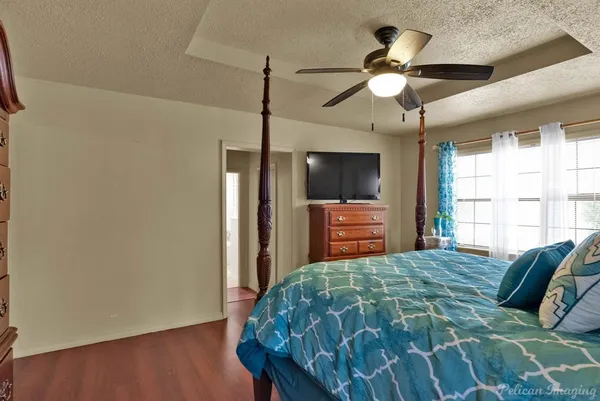 a bedroom with a bed and a flat tv screen on dresser
