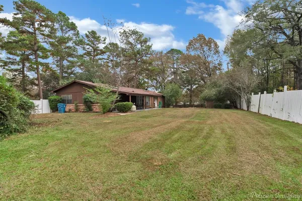 a front view of a house with a yard and trees