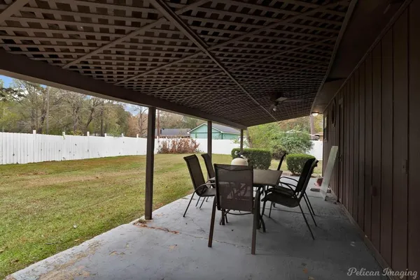 a roof deck with table and chairs and couches with wooden floor