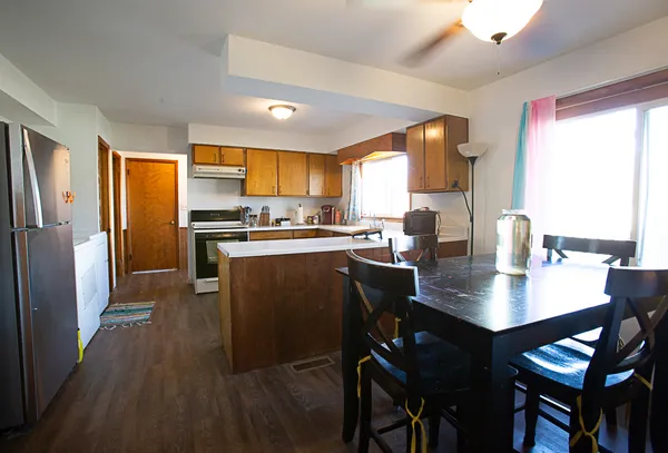 a kitchen with a table chairs refrigerator and cabinets