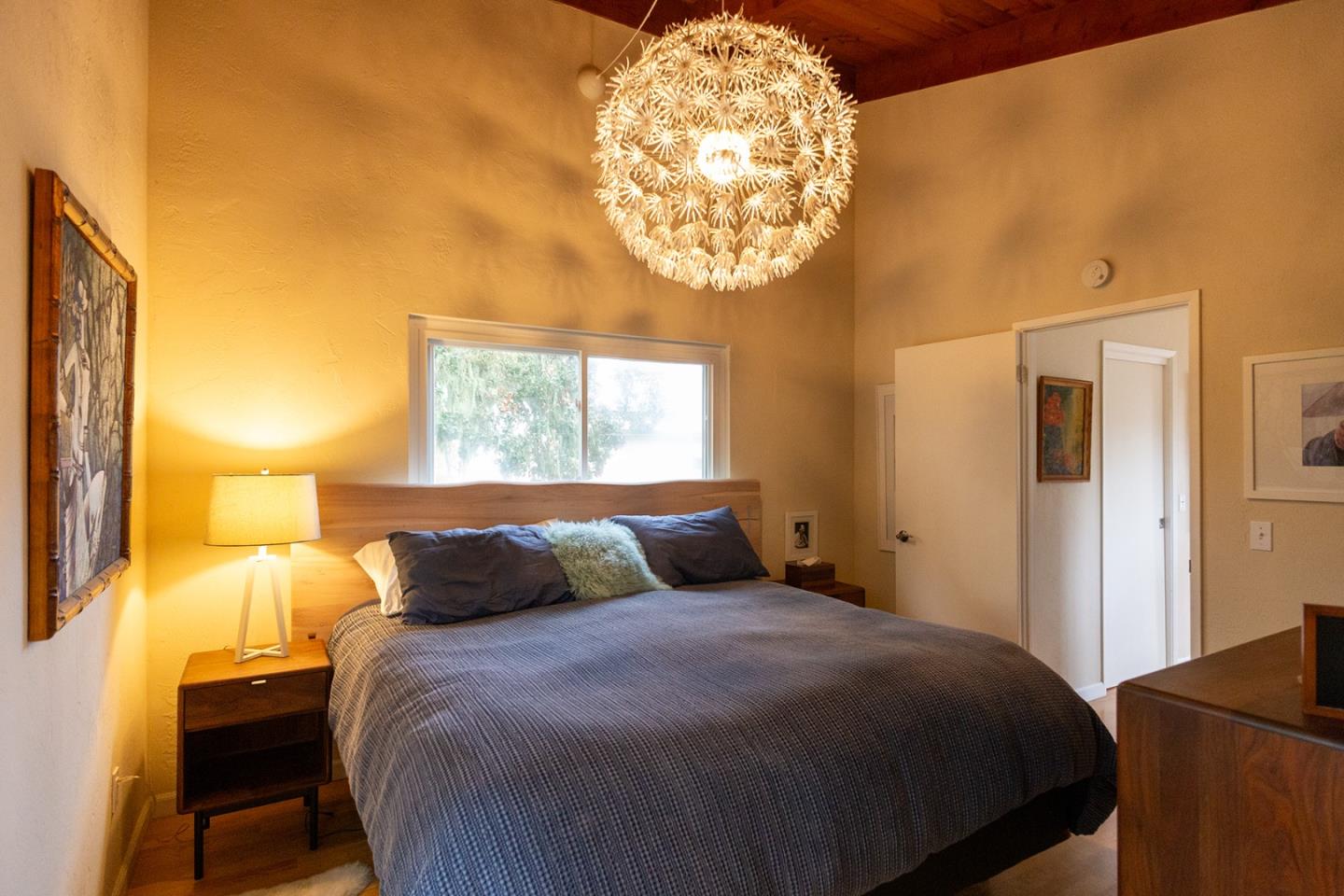 779 Alice Street Monterey, CA 93940 - Photo 11 of 27 a bedroom with a bed and a chandelier