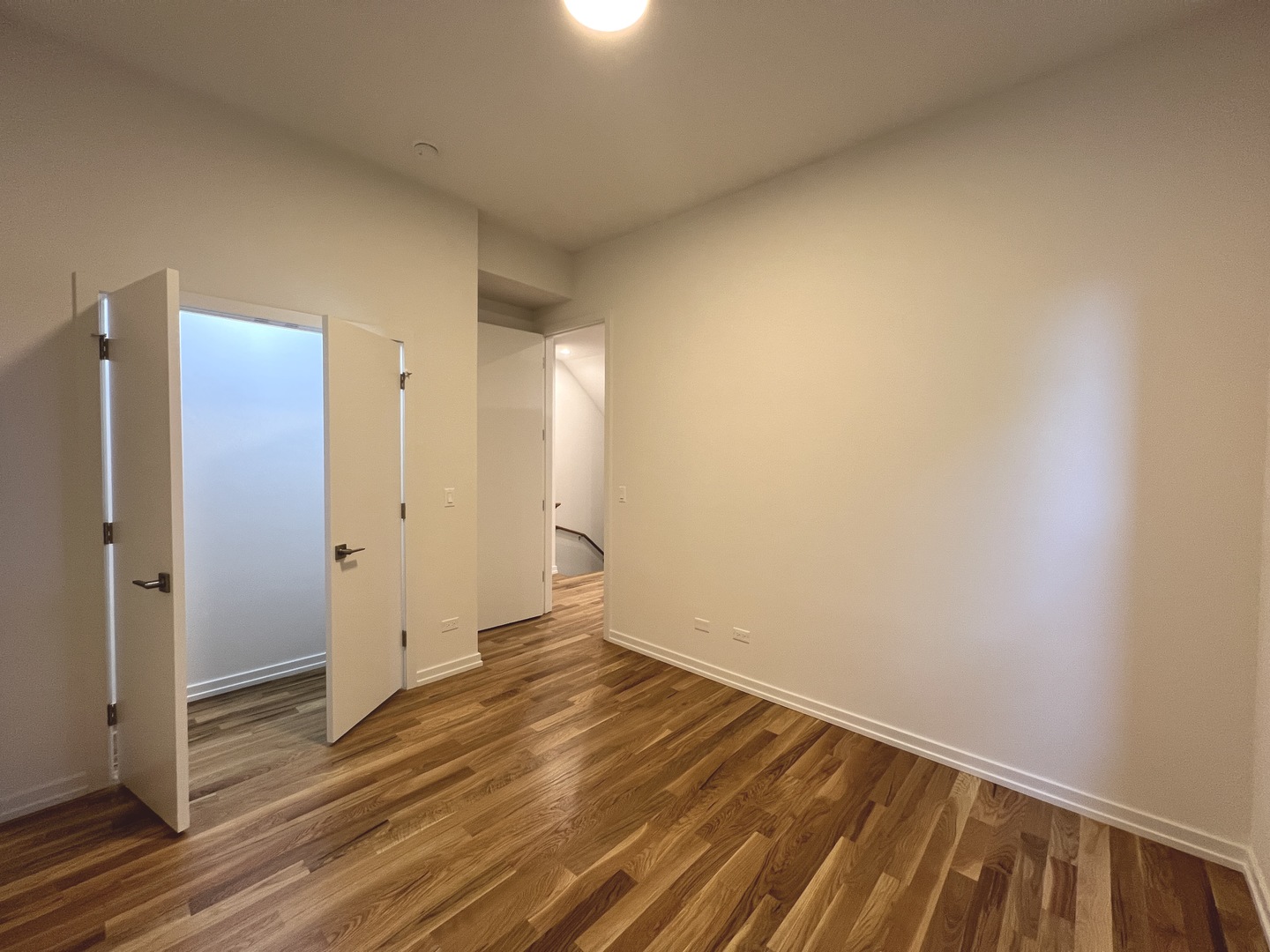 822 North Winchester Avenue, Unit 1F Chicago, IL 60622 - Photo 6 of 17 a view of an empty room with wooden floor and a bathroom