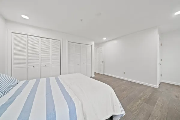 a spacious bedroom with a bed and a night stand