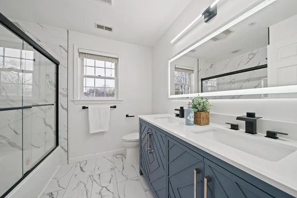 a bathroom with a sink a toilet and shower