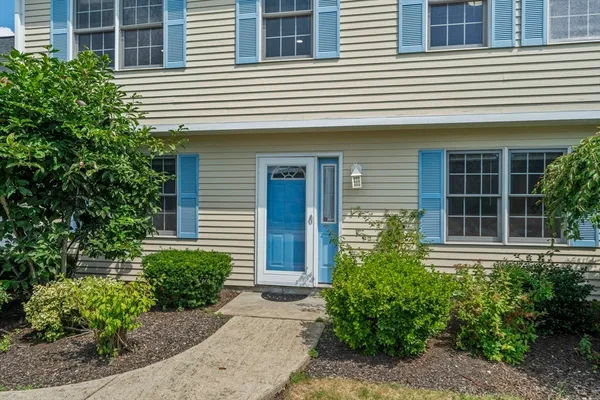 a front view of a house with plants