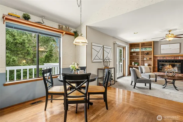 a dining room with furniture garden view and wooden floor