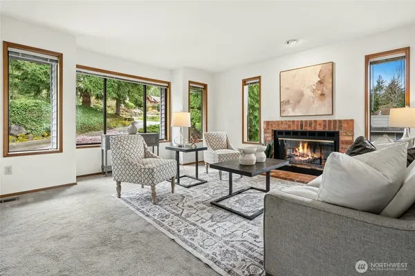 a living room with furniture a large window and a fireplace